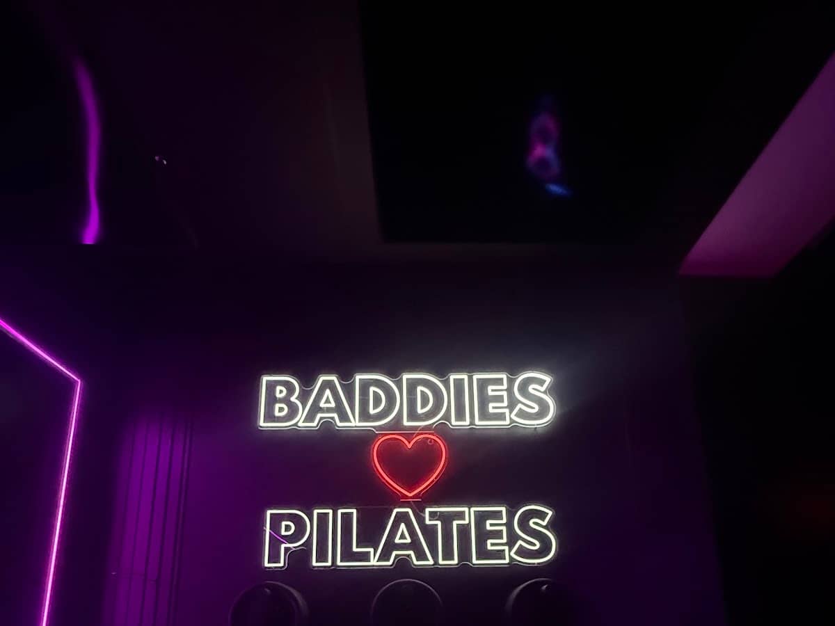 Baddies Love Pilates neon sign in the infrared hot mat pilates room at HILI Fitness Waterford Lakes