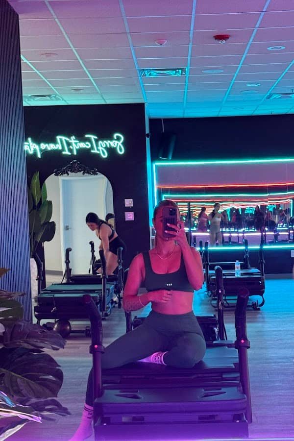 Member taking a mirror selfie on an XFormer pilates machine at HILI Fitness Lake Nona